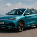 BYD Atto 3 electric SUV in metallic turquoise color parked near a seafront road with city skyline in the background – futuristic design with sleek LED headlamps and alloy wheels